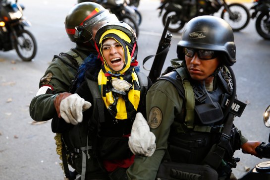 National guards transport an anti-government protester detainee during a protest against Nicolas Maduro's government in Caracas