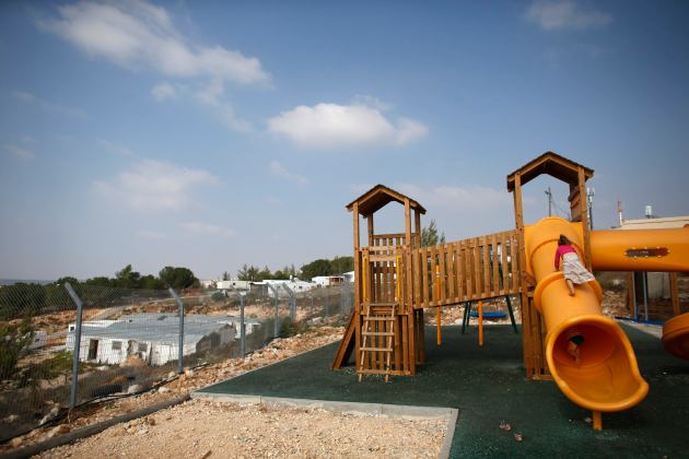 Children climb on a slide at a playground in a Jewish settlement,  near Bethlehem