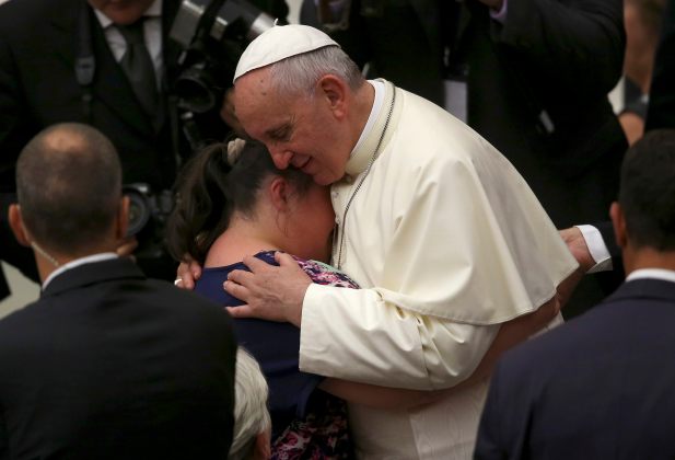 Pope Francis embraces a woman during his Wednesday general audience in the Paul VI hall at the Vatican