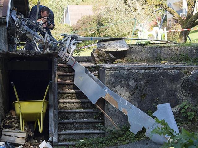  Un policía hace fotografías en el lugar donde un helicóptero se ha estrellado, cerca de una vivienda familiar en Bart, Francia.EFE