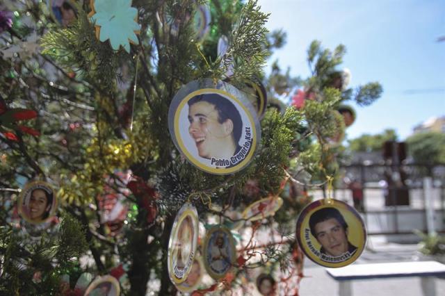 Fotografía del 10 de diciembre de 2014, en la que se observa un árbol con fotografías de algunas de las víctimas del incendio, en los alrededores del lugar donde se ubicaba la discoteca Cromañón en Buenos Aires (Argentina). Sobrevivientes y familiares de las 194 víctimas del incendio de la discoteca Cromañon de Buenos Aires reclaman justicia al cumplirse hoy, 30 de diciembre de 2014, diez años de la tragedia. EFE/David Fernández