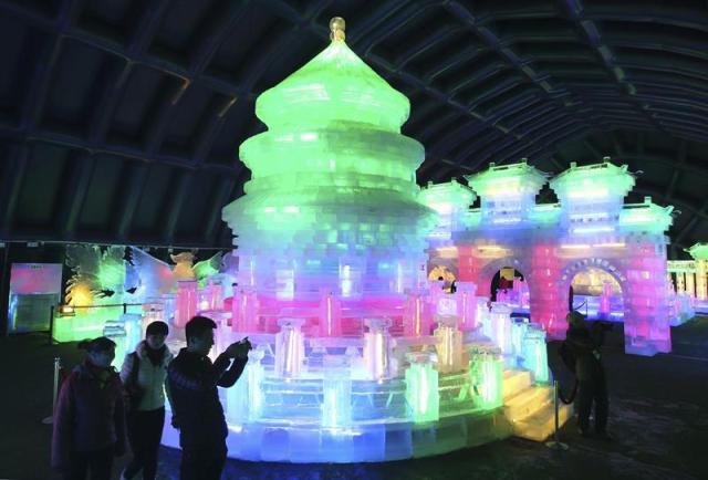  Unas personas hacen fotografías de unas esculturas de hielo iluminadas con luces multicolores en el Festival de las Linternas de Hielo en Pekín, China, hoy, martes 30 de diciembre de 2014. La presente edición de este evento se celebra del 30 de diciembre de 2014 al 13 de febrero de 2015. EFE/Wu Hong