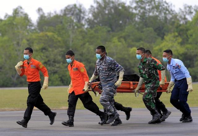 Oficiales indonesios trasladan el cadáver de una víctima del avión de AirAsia estrellado en el mar de Java a su llegada al aeropuerto militar Iskandar en Pangkalan Bun, Borneo Central (Indonesia), hoy, 7 de enero de 2015. Los equipos de rescate encontraron hoy la cola del avión en el fondo del mar de Java donde el aparato se estrelló el pasado 28 de diciembre con 162 personas a bordo, informaron hoy fuentes oficiales. EFE/BAGUS INDAHONO