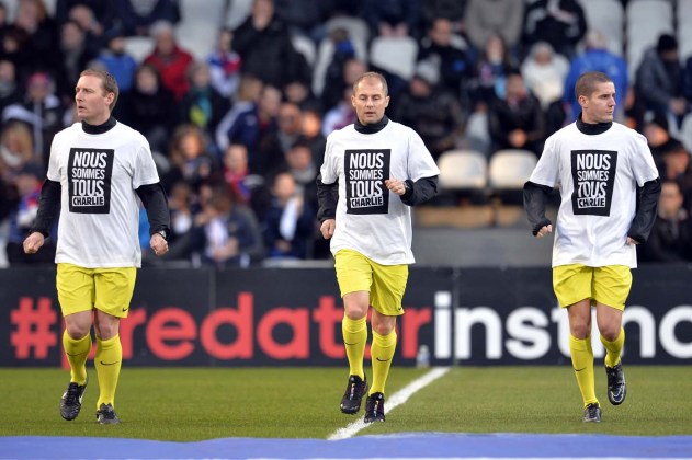 Los árbitros llevan camisetas de lectura en francés "Soy Charlie " en homenaje a las víctimas de un ataque mortal contra la sede de París del semanario satírico francés Charlie Hebdo durante el calentamiento antes del partido de fútbol francesa L1 entre Lyon ( OL ) y Toulouse ( TFC ) el 11 de enero de 2015 el estadio de Gerland en Lyon. AFP