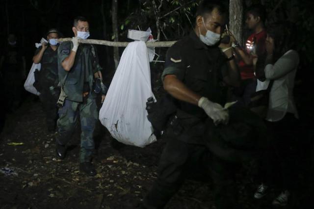 Miembros de la policía de Malasia llevan una bolsa con restos humanos en Wang Kelian, Perlis, Malasia, hoy 28 de mayo de 2015. La policía encontró restos humanos de nueve personas posiblemente relacionados con el tráfico de inmigrantes, tras el descubrimiento de 139 tumbas en 28 campos clandestinos para inmigrantes en el norte del país que contenían cada una los restos de una sola persona y no de varias, tal como se temía inicialmente. Las autoridades de Tailandia descubrieron a principios de mayo 8 campamentos, decenas de tumbas y rescataron más de 300 inmigrantes, incluidos unos 60 rohinyás, una minoría musulmana perseguida en partes de Bangladesh y Birmania. EFE/Fazry Ismail