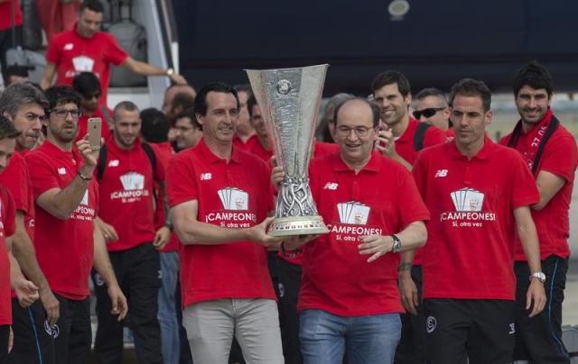  El entrenador del Sevilla, Unai Emery (i), el capitán Fernando Navarro (d) y el presidente del club, José Castro (c), junto al resto de la plantilla, descienden con la copa de la Liga Europa, a su llegada esta tarde al aeropuerto san Pablo de Sevilla, tras vencer anoche al Dnipro durante la Final de la Liga Europa celebrada en el Estadio Nacional de Varsovia. EFE/Julio Muñoz