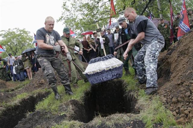 Varios rebeldes prorrusos entierran el ataúd con los restos mortales de Alexéi Mozgovói, jefe de una brigada de milicianos prorrusos, durante su funeral en Alchevsk, en la región de Lugansk, Ucrania, hoy, miércoles 27 de mayo de 2015. Mozgovói, de 40 años, murió el pasado 23 de mayo en una carretera de la región de Lugansk, cuando el microbús en que viajaba fue alcanzado por la explosión de una mina y luego ametrallado por un grupo. EFE/Alexander Ermochenko