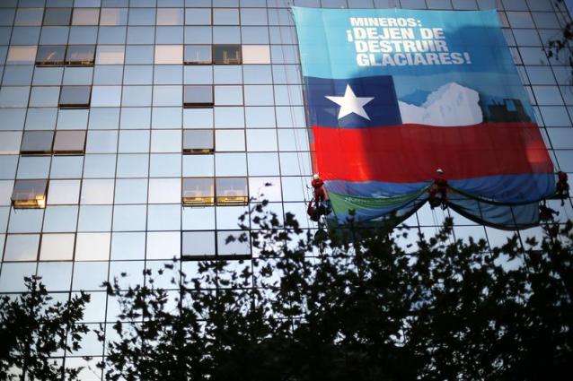 Activistas de República Glaciar de Greenpeace escalan un edificio y despliegan una pancarta hoy, jueves 14 de mayo de 2015, como una acción de protesta para defender los glaciares destruidos por las mineras en una de la principales avenidas en Santiago de Chile. EFE/Mario Ruiz