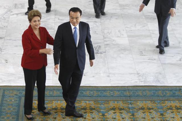 La presidenta brasileña, Dilma Rousseff (i), recibe al primer ministro de China, Li Keqiang (d), hoy, martes 19 de mayo de 2015, en el Palacio presidencial de Planalto en Brasilia (Brasil). Rousseff recibió con honores de Estado a Li Keqiang, quien inicia en Brasilia una gira que le llevará también a Colombia, Perú y Chile. Li llegó a Brasilia la noche de este lunes y hoy se dirigió al Palacio presidencial de Planalto, donde, tras pasar revista a tropas del Batallón de Dragones de la Independencia, fue recibido con un apretón de manos por la mandataria brasileña en lo alto de una rampa que conduce al primer piso de la sede del Gobierno. EFE/Fernando Bizerra Jr