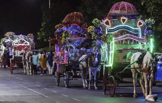 Varios cocheros indios con sus llamados "carruajes Victoria" esperan a los turistas para recorrer de noche las calles de Bombay, India, hoy 9 de junio de 2015. Un Tribunal Supremo regional prohibió estos carruajes, una de las atracciones de la ciudad, al declararlos ilegales y ordenó su desaparición en el plazo de un año. La corte pidió sin embargo una ayuda gubernamental para indemnizar a las 700 familias afectadas por el cese de la actividad, incluyendo una ayuda para cuidar de sus caballos. EFE/Divyakant Solanki