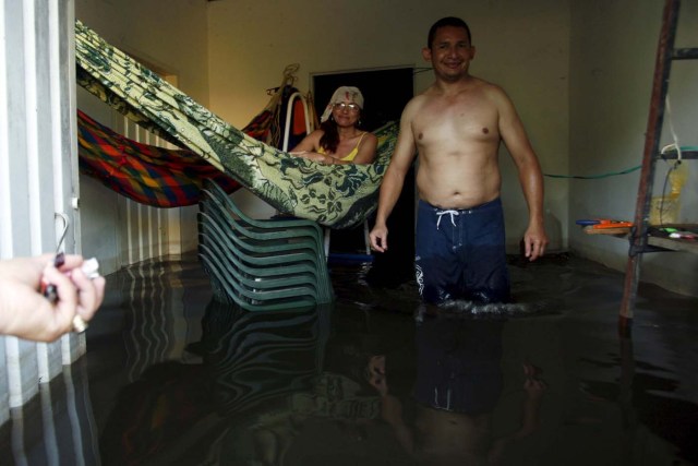 People are seen in to a flooded house in Guasdualito, in the state of Apure, Venezuela