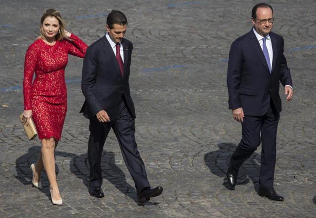 El presidente francés, François Hollande (d), camina junto a su homólogo mexicano, Enrique Peña Nieto, y su mujer, Angélica Rivera, a su llegada al tradicional desfile militar de la Fiesta Nacional francesa en París (Francia), hoy, 14 de julio de 2015. EFE/IAN LANGSDON