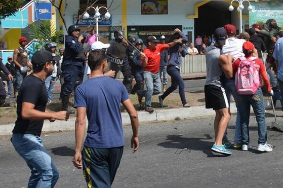 Chavista ataca con tubo en mano a opositora bajo la mirada policial (Foto)