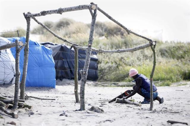 Un inmigrante construye un refugio en un campamento improvisado en Calais, Francia, hoy, 29 de julio de 2015. La muerte anoche de un inmigrante clandestino en Calais, en la entrada francesa del túnel ferroviario que conduce al Reino Unido bajo el canal de la Mancha, ha llevado hoy a París a reforzar la seguridad en el lugar, donde se contabilizan unos 3.000 inmigrantes y donde nueve de ellos han perdido la vida en dos meses. El número de inmigrantes en Calais se ha incrementado en las últimas semanas ante la afluencia de camiones, tras el cierre parcial del puerto por el conflicto social que paraliza la empresa de ferrys MyFerryLink. EFE/YOAN VALAT