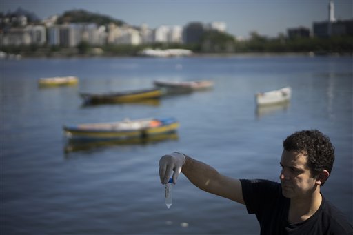 En esta imagen del 28 de abril de 2015, Fernando Spilki, virólogo y coordinador del programa de calidad ambiental en la Universidad Feevale, sostiene una muestra de agua, con la Zona 2 de la Marina da Gloria de Río de Janeiro, Brasil, de fondo. Spilki dijo que las pruebas realizadas por Associated Press muestran hasta ahora que las aguas de Río ?sufren de contaminación crónica?. (Foto AP/Felipe Dana)