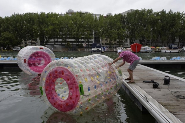 Foto: Un hombre prepara un juego de la burbuja de plástico hecho en los muelles Villette en París, el 20 de julio de 2015, durante la inauguración de la 14ª edición de 'Paris Plages. Del 20 de julio al 23 de agosto 2015, los parisinos y los turistas pueden disfrutar de las playas artificiales temporales en la ciudad. AFP