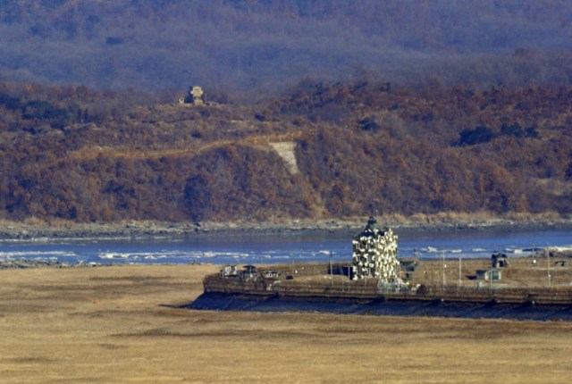 (FILES) In file photo taken on January 25, 2013, a North Korean guard post (top) and a South Korean guard post (centre R) stand opposite each other as seen from a South Korean observation post in Paju near the Demilitarized Zone (DMZ) dividing the two Koreas. South Korea on August 20, 2015 fired dozens of shells across the border into North Korea in retaliation for an apparent North Korean rocket attack, Seoul's defence ministry said.   AFP PHOTO / FILES / JUNG YEON-JE