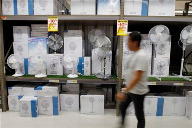 ARCHIVO - En esta foto de archivo del 3 de julio de 2015, una persona pasa frente a un escaparate de tienda lleno de ventiladores en Marsella. La Tierra sigue recalentándose. Julio fue el mes más caluroso del planeta desde que se llevan registros, informaron funcionarios del servicio meteorológico estadounidense. (AP Foto/Claude Paris, File)