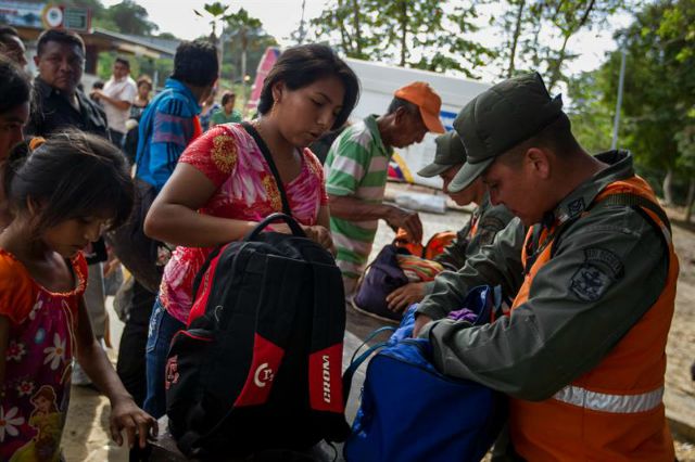 Militares venezolanos son vistos mientras revisan las pertenencias de las personas que intentan cruzar el peaje de Río Limón en Zulia (Venezuela), estado fronterizo con Colombia. Desde que el presidente de Venezuela, Nicolás Maduro, ordenase el cierre de esta parte de la frontera el lunes las autoridades han incrementado la seguridad en esta zona e instalado nuevos puntos de control en todos los poblados aledaños al paso de Paraguachón. EFE/MIGUEL GUTIÉRREZ