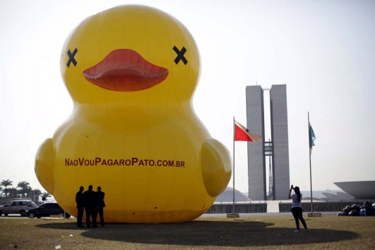 A giant inflatable doll in the shape of a duck is seen in front of the National Congress during a protest against tax increases in Brasilia