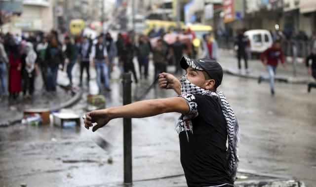 Un palestino se enfrenta a la policía en la localidad cisjordana de Hebrón, Palestina hoy 7 de octubre de 2015. La escala de violencia en la región tras el incremento de las medidas de seguridad en torno a la mezquita de Al Aqsa sigue creciendo, tanto que algunos medios temen que derive en una tercera intifada (revuelta popular palestina), como algunos analistas llevan advirtiendo desde hace días. EFE/Abed Al Haslhamoun