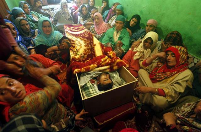 Familiares lloran junto al cadáver de Zahid Rasool Bhat durante su funeral en el pueblo de Batango, al sur de Srinagar, capital estival de la Cachemira india, hoy, 19 de octubre de 2015. Las autoridades indias impusieron estrictas restricciones en diferentes partes de Srinagar y pusieron bajo arresto domiciliario a líderes separatistas en previsión a una posible huelga en protesta contra la muerte del conductor de camiones cachemirí Zahid Rasool Bjhat, quien resultó herido de muerte en un ataque con cóctel molotov contra su camión el pasado día 9. EFE/Farooq Khan