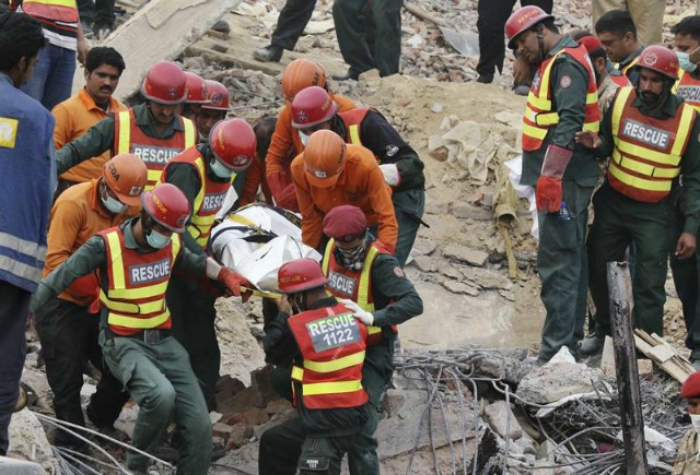 Miembros de los servicios de rescate recuperan un cadáver de entre los escombros de una fábrica que se derrumbó el pasado miércoles, en Lahore (Pakistán), hoy, 6 de noviembre de 2015. Las autoridades tratan de rescatar con pocas esperanzas a cerca de 40 personas que se cree permanecen bajo los escombros del edificio, en el que al menos 25 personas perdieron la vida y otras 100 resultaron heridas. EFE/Rahat Dar