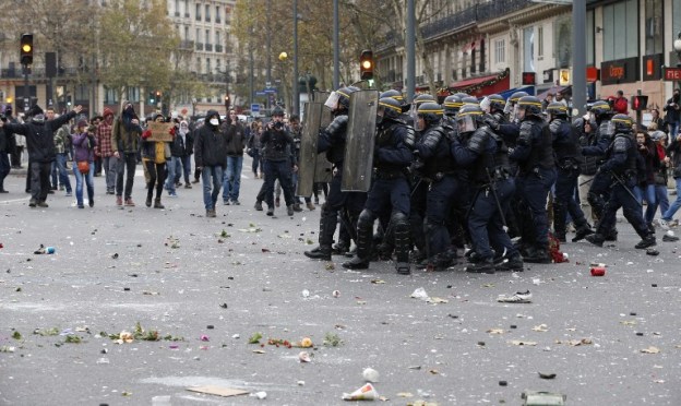 Riot police clash with protestors during a rally against global warming on November 29, 2015 in Paris, a day ahead of the start of UN conference on climate change COP21. French police fired teargas November 29 to disperse climate change activists in Paris who threw objects at them during a demonstration ahead of key UN talks, AFP reporters said.  AFP PHOTO / FRANCOIS GUILLOT / AFP / FRANCOIS GUILLOT