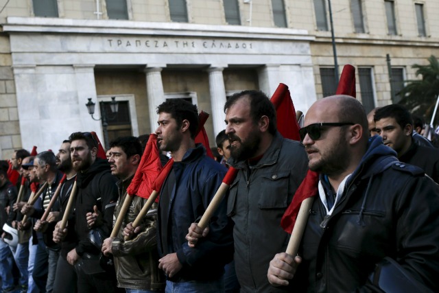 Manifestantes de los lemas comerciales grito PAME unión comunistas afiliados, ya que desfilan la sede del Banco de Grecia, durante una manifestación contra la austeridad que marca un paro de 24 horas en Atenas, Grecia, 03 de diciembre, 2015. Los trabajadores griegos en huelga se llevará a la calles el jueves, lo que altera el transporte, el cierre de las escuelas y de mantenimiento de los buques atracados en puerto en la segunda gran protesta contra los recortes de pensiones previstas en tres semanas. REUTERS / Alkis Konstantinidis