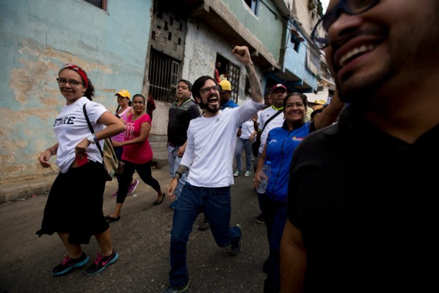 Miguel Pizarro, congresista de la coalición opositora Unidad Democrática, al centro, saluda a partidarios durante un mitin para agradecer a los que votaron por él en el vecindario Petare en Caracas, Venezuela, el sábado 12 de diciembre de 2015. La oposición está organizando mítines en todo el país para festejar su aplastante victoria en las elecciones legislativas del 6 de diciembre. (Foto AP/Fernando Llano)