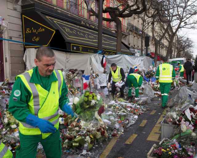 Los trabajadores comienzan a retirar el monumento improvisado para las víctimas de los ataques de disparo de París en la cafetería y sala de conciertos Bataclan en París, 22 de diciembre de 2015. Notas, poemas, dibujos, flores y otras muestras de la conmemoración y el desafío fueron dejados por los transeúntes en memoriales informales frente a los sitios de los ataques de disparo de noviembre en París, en el que 130 personas perdieron la vida. REUTERS / Eddie Keogh