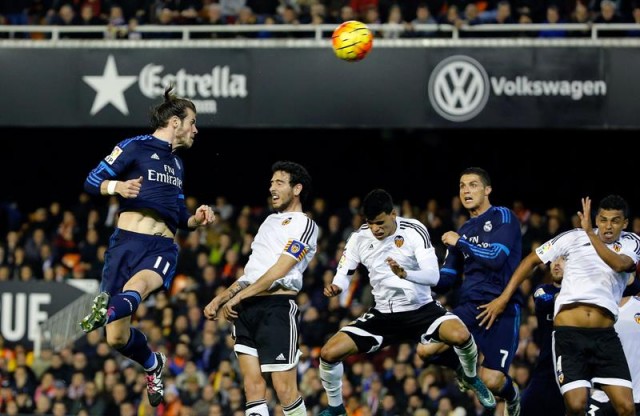 - El delantero galés del Real Madrid Gareth Bale (i) cabecea para conseguir el segundo gol del equipo frente al Valencia CF, durante el partido correspondiente a la décimo octava jornada de Liga en Primera División que se disputa esta noche en el estadio de Mestalla, en Valencia. EFE/Juan Carlos Cárdenas