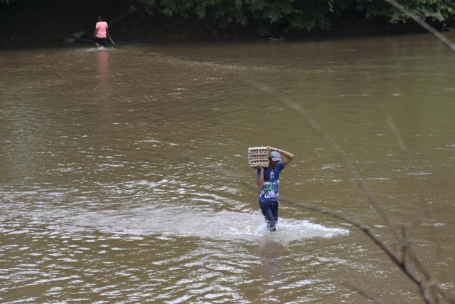 A man carries a carton of eggs across a river in the border town of Boca del Grita in the state of Tachira, Venezuela September 8, 2015. Driven by a deepening economic crisis, smuggling across Venezuela's land and maritime borders - as well as illicit domestic trading - has accelerated to unprecedented levels and is transforming society. Although smuggling has a centuries-old history here, the socialist government's generous subsidies and a currency collapse have given it a dramatic new impetus. To match Insight VENEZUELA-SMUGGLING/  Picture taken September 8, 2015. REUTERS/Girish Gupta