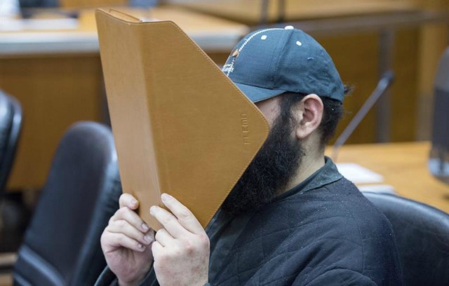 El presunto islamista Halil Ibrahim D. esconde su rostro tras una carpeta en una sala del Tribunal Provincial de Fráncfort (Alemania) hoy, 21 de enero de 2016. El presunto islamista Halil Ibrahim D., se enfrenta a su juicio acusado de planear un atentado terrorista. EFE/Alexander Heinl