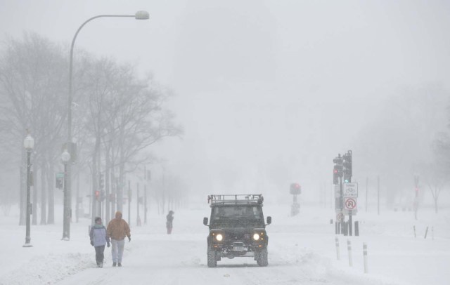 People walk during a winter storm on Pennsylvania Avenue in Washington January 23, 2016. A winter storm dumped nearly 2 feet (58 cm) of snow on the suburbs of Washington, D.C., on Saturday before moving on to Philadelphia and New York, paralyzing road, rail and airline travel along the U.S. East Coast.      REUTERS/Joshua Roberts