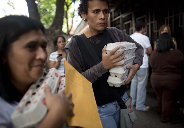 En esta imagen del miércoles 27 de enero de 2016, gente con cajas de huevos tras comprarlos a precios regulados por el gobierno en Caracas, Venezuela. Hay un desabastecimiento de huevos en el país. En una nota publicada el pasado viernes, el director del Fondo Monetario Internacional para el hemisferio oeste, Alejandro Werner, dijo que este año la inflación podría más que multiplicarse por dos en el país, hasta alcanzar el 720%. (AP Foto/Ariana Cubillos)