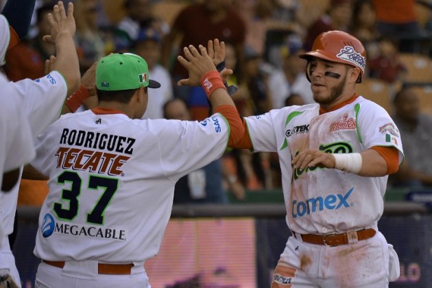 Guillermo Antonio Quiroz (R) of Mexico celebrates his homerun against Venezuela during their 2016 Caribbean baseball series game on February 7, 2016 in Santo Domingo, Dominican Republic. AFP PHOTO/YAMIL LAGE / AFP / YAMIL LAGE