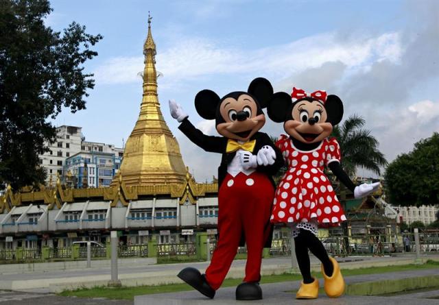 Fotografía de archivo tomada el 25 de septiembre de 2014 que muestra a los personajes de Disney Mickey Mouse (i) y Minnie Mouse frente a la pagoda de Suu lay en Rangún (Birmania). La compañía Walt Disney tiene previsto publicar hoy, 9 de febrero de 2015, sus resultados trimestrales. EFE/LYNN BO BO