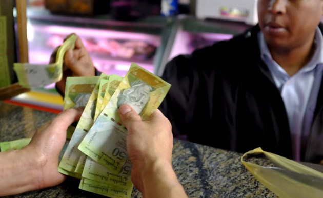 A cashier counts bolivar notes at a butchery in a public market in Caracas, Venezuela January 22, 2016. Venezuela's opposition refused on Friday to approve President Nicolas Maduro's "economic emergency" decree in Congress, saying it offered no solutions for the OPEC nation's increasingly disastrous recession. Underlining the grave situation in Venezuela, where a plunge in oil prices has compounded dysfunctional policies, the International Monetary Fund on Friday forecast an 8 percent drop in gross domestic product and 720 percent inflation this year. REUTERS/Marco Bello