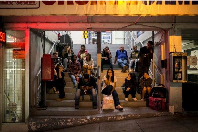 Un grupo de cubanos espera sentado en las escaleras de la sede de la organización Cubanos en Libertad en la ciudad de Laredo, Texas. Credit Ilana Panich-Linsman para The New York Times