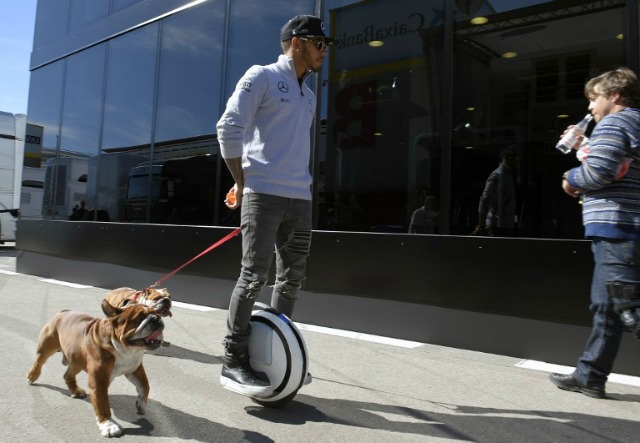 El piloto británico de Mercedes AMG Petronas F1 del equipo Lewis Hamilton utiliza un largo camino para caminar a sus perros en el paddock del Circuit de Catalunya en Montmeló, en las afueras de Barcelona, en el día de la prueba de la temporada de Fórmula Uno Gran Premio el 1 de marzo de 2016. LLUIS GENE / AFP