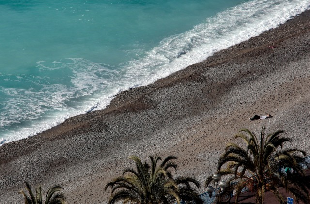 Una mujer descansa en la playa durante un día templado y soleado de invierno en Niza, Francia, 1 de marzo de 2016. REUTERS / Eric Gaillard