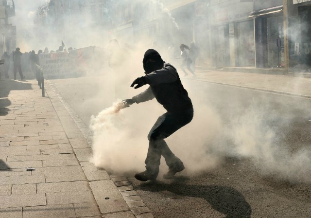 A los manifestantes lanza de nuevo un bote de gas lacrimógeno lanzado por la policía antidisturbios durante una manifestación contra la reforma de la legislación laboral el 31 de marzo, 2016, Rennes, Francia del noroeste. Francia se enfrentó a nuevas protestas sobre la reforma laboral sólo un día después de que el acosado gobierno del presidente Francois Hollande se vio obligado en una embarazosa vuelta en U sobre los cambios constitucionales. Jean-Francois MONIER / AFP