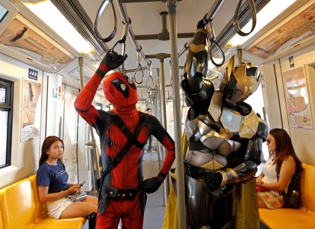 Dos fans tailandeses, disfrazados de los superhéroes Deadpool (izq) y de un robot, utilizan el transporte público para promocionar la próxima celebración de las Bangkok Entertainment Weeks 2016, en Bangkok (Tailandia) hoy, 19 de abril de 2016. Este evento se celebra del 27 de abril de 3 mayo. EFE/Rungroj Yongrit