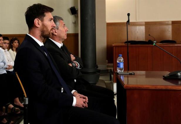 El jugador del FC Barcelona Lionel Messi y su padre, Jorge Horacio Messi (d), en la sala de la Audiencia de Barcelona durante la tercera jornada del juicio que se sigue contra ellos por tres delitos contra la Hacienda Pública, en una vista en la que el fiscal no ejerce la acusación contra el delantero, mientras la Abogacía del Estado pide 22 meses de prisión. EFE/Alberto Estévez