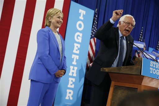 La virtual nominada a la presidenia por el Partido Demócrata, Hillary Clinton, escucha a Bernie Sanders, también contendiente a la presidencia por el mismo partido, durante un mitin en Portsmouth, New Hampshire, el martes 12 de julio del 2016, donde Sanders respaldó a Clinton a la presidencia. (Foto AP /Andrew Harnik)