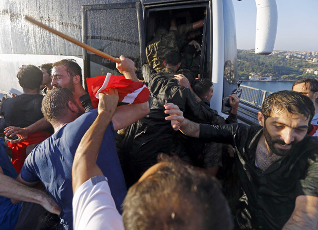 Soldiers push each other to board a bus to escape the mob after troops involved in the coup surrendered on the Bosphorus Bridge in Istanbul, Turkey July 16, 2016. REUTERS/Murad Sezer