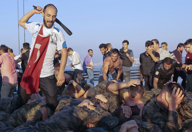 Surrendered Turkish soldiers who were involved in the coup are beaten by a civilian on Bosphorus bridge in Istanbul, Turkey, July 16, 2016. REUTERS/Stringer EDITORIAL USE ONLY. NO RESALES. NO ARCHIVES. TPX IMAGES OF THE DAY