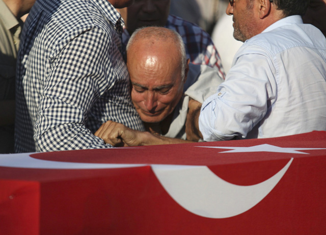 A man mourns over the coffin holding body of police officer Nedip Cengiz Eker during a funeral ceremony in Marmaris, Turkey, July 16, 2016. REUTERS/Kenan Gurbuz