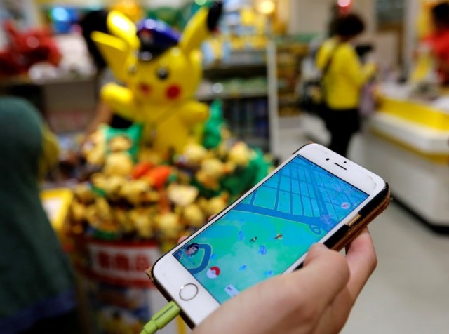 Un hombre juega Pokemon Go frente a una tienda que vende artículos de Pokemon, en Tokio, Japón. Foto: REUTERS/Toru Hanai